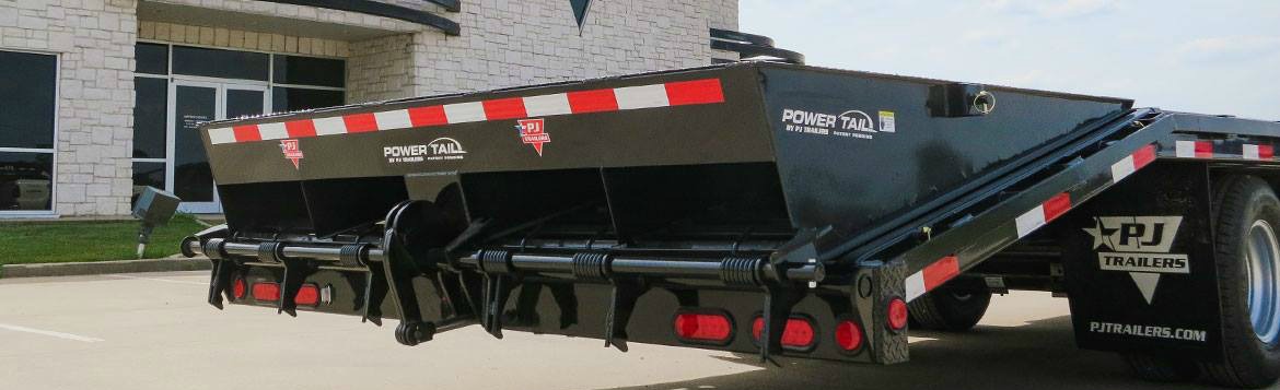 A black PJ flatbed trailer sitting in a parking lot.